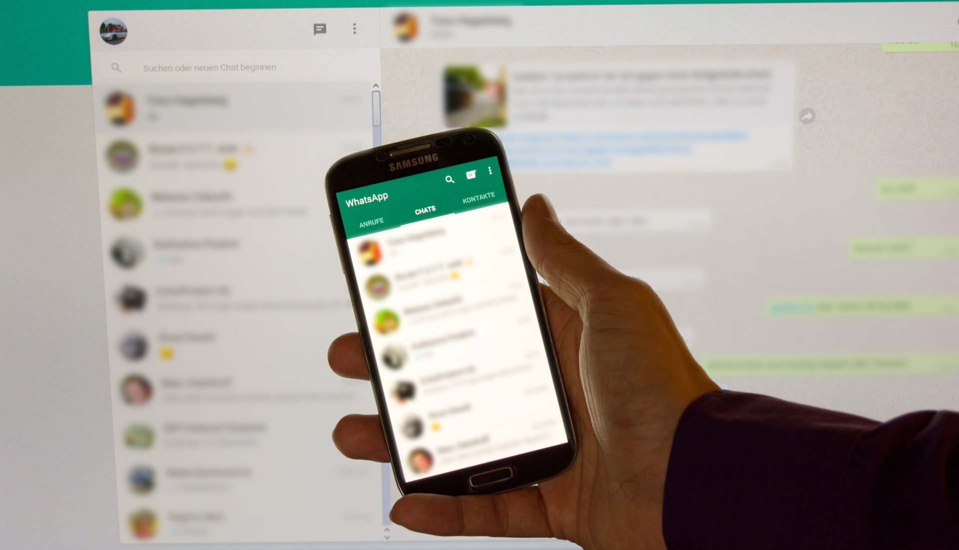 Smartphone mit WhatsApp Web im Hintergrund